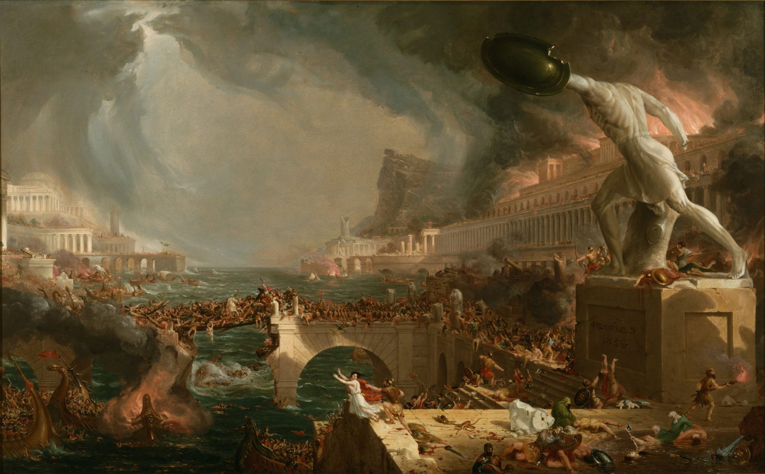 A classical city engulfed in flames and black smoke under a violent, swirling storm. In the foreground, a headless marble warrior statue raises its shield on a pedestal above citizens fleeing and fighting along the quay. A stone arch bridge crowded with soldiers and civilians collapses across the harbor as ships burn and collide in the water below.